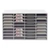 A white multi-section organizer with magazines, books, and green items in some compartments. Náhled obrázku produktu