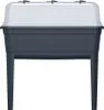 A front view of a dark grey plastic steamer on legs with a clear lid. Náhled obrázku produktu