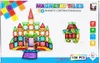 The image shows the packaging of a magnetic tile building block set for children. The packaging displays a large castle built from the tiles, a small robot figure, and various colorful tiles. There is also text and logos on the packaging. Náhled obrázku produktu