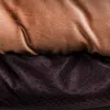 A close-up view of the textured fabric of a dog bed, showing the plush top layer and the non-slip dotted underside. Produktbild-Vorschau