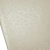 A close-up, angled view of a cream-colored tablecloth with a damask floral pattern. Produktbild-Vorschau