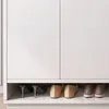 A low-angle shot of a white cabinet with shoes stored on the bottom shelf. Náhled obrázku produktu