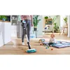 A woman is using a vacuum cleaner in a home environment, with a baby playing nearby. Náhled obrázku produktu