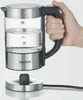 A hand holding a glass kettle above its base. Produktbild-Vorschau