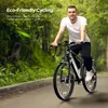 A man is riding an electric bicycle on a paved path surrounded by trees and greenery. Produktbild-Vorschau