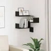 Two black wall shelves are mounted in a corner of a room, displaying books, a plant, and framed pictures. A portion of a sofa and a large green plant are visible in the foreground. Náhled obrázku produktu