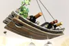 A wooden wine rack hanging from the ceiling, holding several bottles of wine and wine glasses underneath. Produktbild-Vorschau