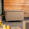 An outdoor storage box on a patio with a wooden wall in the background and some fruit in the foreground. Produktbild-Vorschau