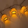 A string of decorative lights with woven cylindrical shades. Produktbild-Vorschau