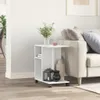 A white side table with wheels is placed next to a sofa in a living room. Produktbild-Vorschau