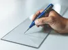 A hand holding a blue marker and drawing a line on a clear surface. Produktbild-Vorschau