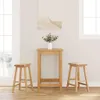 A bar table and two bar stools are set up in a room with a window and a painting on the wall. Produktbild-Vorschau