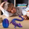 A young boy is sleeping at a desk with a 3D printed dragon and egg in front of him. Produktbild-Vorschau