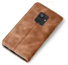 A brown leather flip case for a smartphone, shown from the back with the camera cutout visible. Produktbild-Vorschau