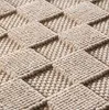 A close-up view of a woven beige rug with a diamond pattern. Podgląd zdjęcia produktu