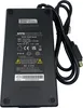 A black AC/DC power supply with a cable attached, lying on a light gray surface. Podgląd zdjęcia produktu