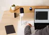 A person's hand is connecting a cable to a laptop on a desk, with a microphone and a small plant in the background. Náhled obrázku produktu