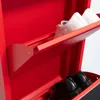 A close-up view of a red shoe cabinet with shoes on its shelves. Voir les images du produit