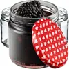 A close-up of a glass jar filled with blackberries and jam, with a red lid decorated with white hearts. Voir les images du produit