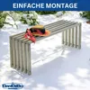 A metal bench with a straw hat and scarf on it, placed outdoors in a garden setting with dappled sunlight. Produktbild-Vorschau