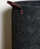 Close-up of a woven grey felt laundry basket with brown leather handles. Produktbild-Vorschau