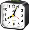 A close-up studio shot of a black analog alarm clock with a white face. Produktbild-Vorschau