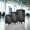 Three black suitcases of varying sizes are lined up in an airport terminal. Voir les images du produit