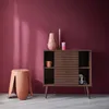 A modern living room scene with a wooden sideboard, a stool, and decorative items. Anteprima dell’immagine prodotto