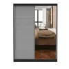 A wardrobe with mirrored doors reflecting a bedroom interior. Voir les images du produit