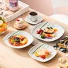A beautifully set table with a variety of dishes, including soup, fish, and dessert, along with a cup of tea and fruit. Náhled obrázku produktu