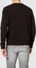 A person wearing a black sweatshirt and gray jeans, viewed from the back. Náhled obrázku produktu