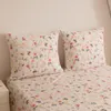A close-up view of a bed with floral patterned bedding and pillows. Produktbild-Vorschau