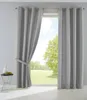 A room interior with a large window covered by gray curtains, overlooking a green landscape. Produktbild-Vorschau