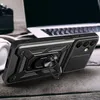 A black phone case with a ring stand is displayed on a wooden surface next to a laptop and headphones. Anteprima dell’immagine prodotto