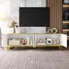 A white and gold TV stand with its doors open, displaying various decorative items and storage boxes, set against a marble-tiled wall. Náhľad obrázku produktu
