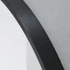 A close-up view of a black framed mirror against a textured gray wall. Náhľad obrázku produktu