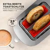 A close-up of a toaster with bagels inside, next to a cup of coffee. Produktbild-Vorschau