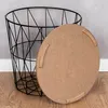 A black wire basket with a round wooden lid next to it, placed on a wooden floor against a grey wall. Produktbild-Vorschau