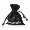 A black drawstring pouch with the brand name 'MATERIA' printed in white. Produktbild-Vorschau