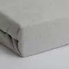 A close-up view of a folded gray terry cloth fitted sheet. Produktbild-Vorschau