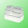 A set of clear plastic food storage containers with gray lids, stacked on a light green background. Produktbild-Vorschau