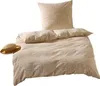 A bedding set with a pillow and duvet cover, along with a straw hat, laid out on a white background. Produktbild-Vorschau