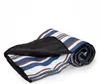A rolled-up picnic blanket with a striped pattern and a black waterproof backing. Anteprima dell’immagine prodotto