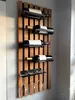 A wooden wine rack mounted on a wall, holding several bottles of wine and wine glasses. Produktbild-Vorschau