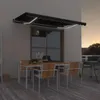 An outdoor patio scene at dusk with a table and chairs set up under a retractable awning with LED lights. Náhľad obrázku produktu
