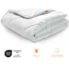A folded white comforter is shown against a white background, with certification logos and text below. Voir les images du produit