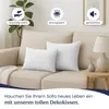 Two white decorative pillows are placed on a beige sofa. Produktbild-Vorschau