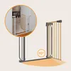 A baby gate shown in two configurations: one installed in a doorway and another demonstrating its 90-degree angle capability. Náhled obrázku produktu