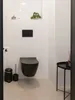 A modern black wall-mounted toilet in a bathroom. Produktbild-Vorschau