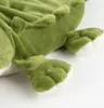 A close-up shot of the feet and lower body of a green plush toy crocodile. Podgląd zdjęcia produktu